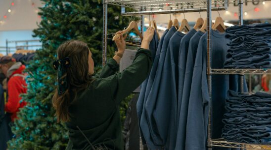 A staff member arranges merchandise for sale at the Muny Holiday Pop-Up Shop